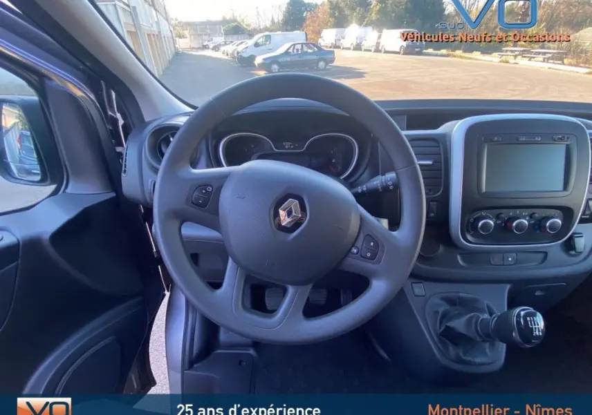 Vue intérieure frontale du Renault Trafic Combi gris clair 2019, volant multifonction et tableau de bord avec écran tactile.