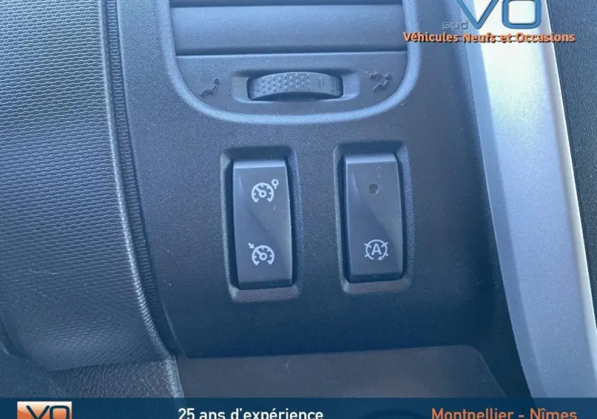 Gros plan sur les commandes du régulateur de vitesse et Stop & Start du Renault Trafic Fourgon gris clair, intérieur 2019.