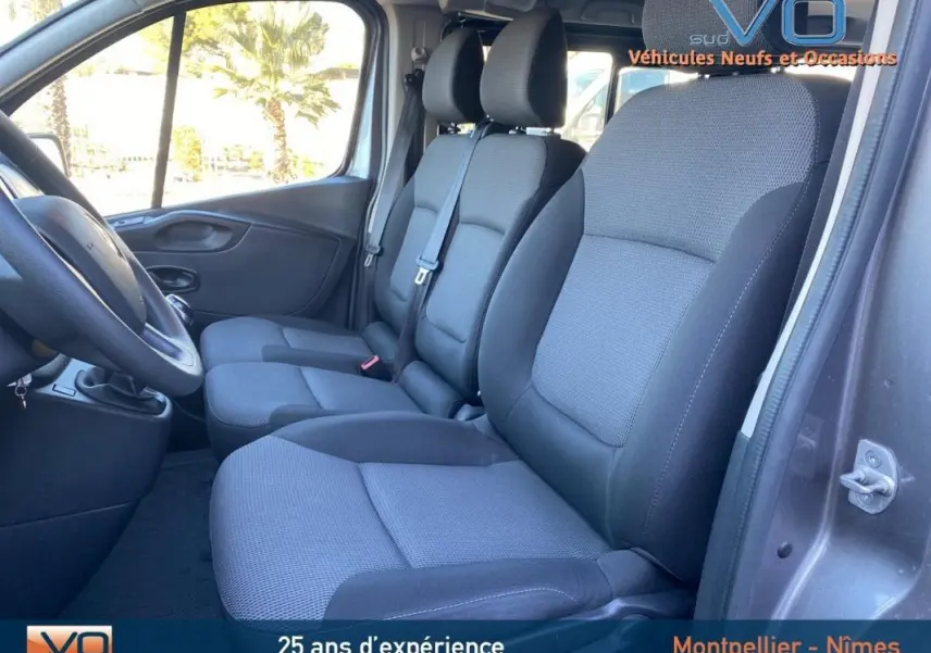 Intérieur du Renault Trafic Fourgon gris clair 2019, vue latérale sur les sièges avant en tissu gris et noir.