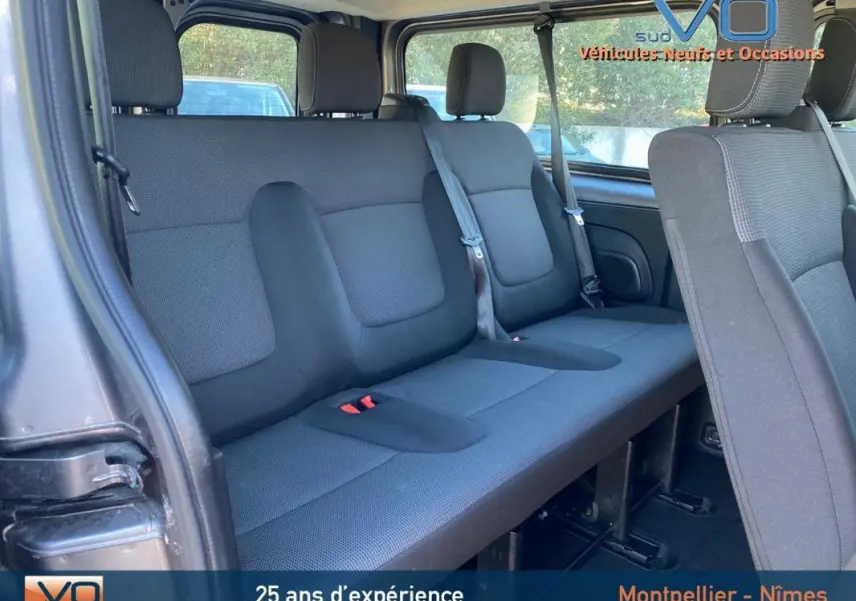 Banquette arrière vue de côté gauche du Renault Trafic Fourgon Combi gris clair, montrant les sièges et ceintures de sécurité.