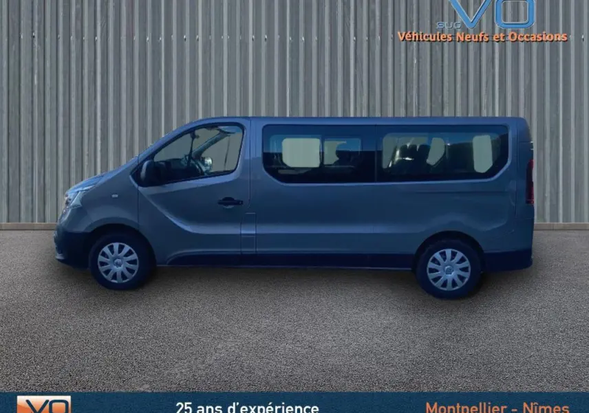 Profil côté gauche du Renault Trafic Combi gris clair 2019 avec grandes vitres latérales sur fond neutre.