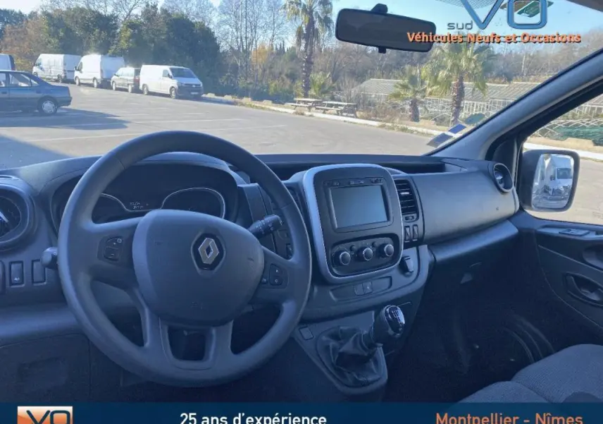 Intérieur du Renault Trafic Combi gris clair, vue côté conducteur sur tableau de bord et volant avec écran central.