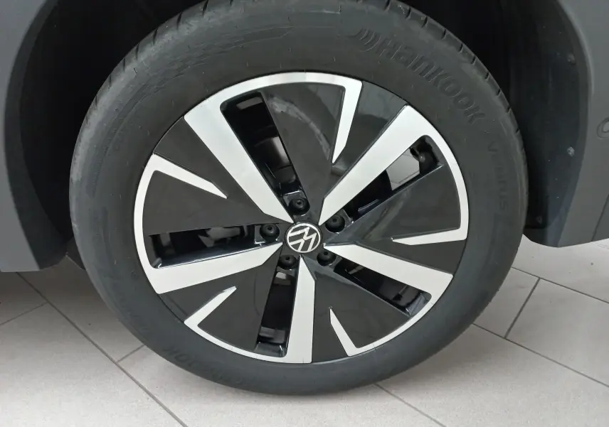 Gros plan sur la jante noire et brillante Catania 19 pouces du Volkswagen Tiguan 2025 en Vert Cipressino.