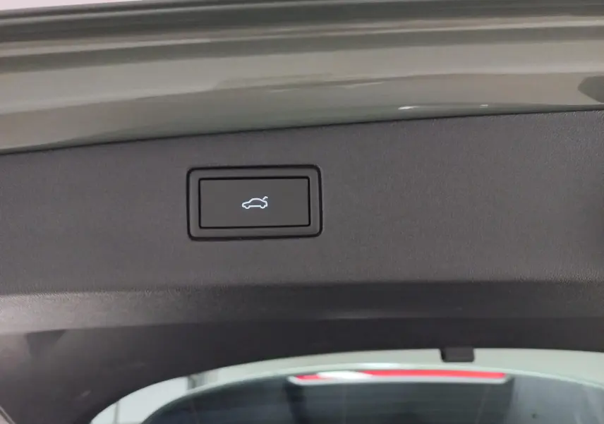 Bouton d'ouverture électrique du coffre sur la partie intérieure du hayon d'un Volkswagen Tiguan Vert Cipressino 2025.