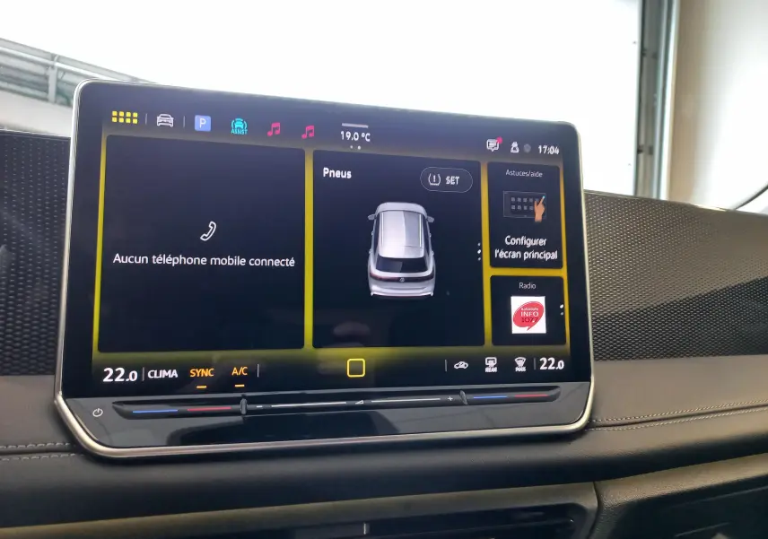 Tablette tactile du tableau de bord du Volkswagen Tiguan 2025 affichant la température et l'état des pneus.