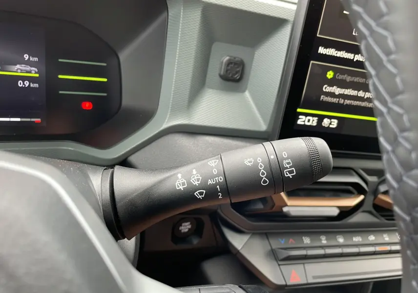 Gros plan sur la commande d’essuie-glace côté gauche du tableau de bord du Dacia Duster 2025, intérieur noir.