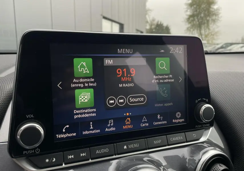 Écran tactile central du Nissan Juke 2024 affichant la radio FM à 91,9 MHz dans un intérieur gris.