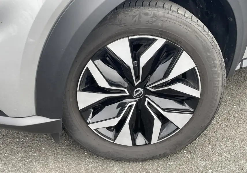 Gros plan sur la roue avant gauche du Nissan Juke 2024 gris Silver, avec jante alliage bicolore noire et argentée.