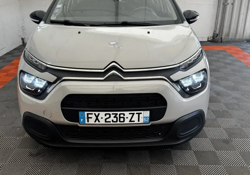 Vue avant d'une Citroën C3 beige 2021 avec phares LED allumés et calandre noire distinctive.