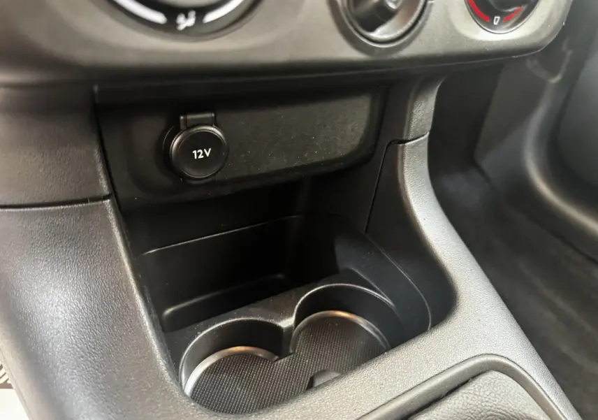 Gros plan sur la prise 12V et les porte-gobelets noirs dans l'habitacle de la Citroën C3 beige 2021.