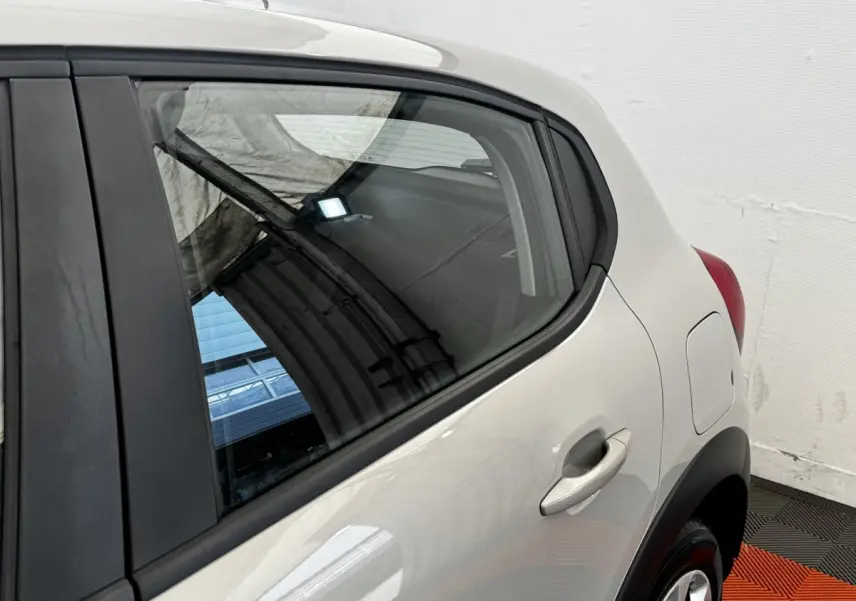 Vue rapprochée du côté arrière droit d'une Citroën C3 beige 2021, mettant en valeur la porte et la trappe à carburant.