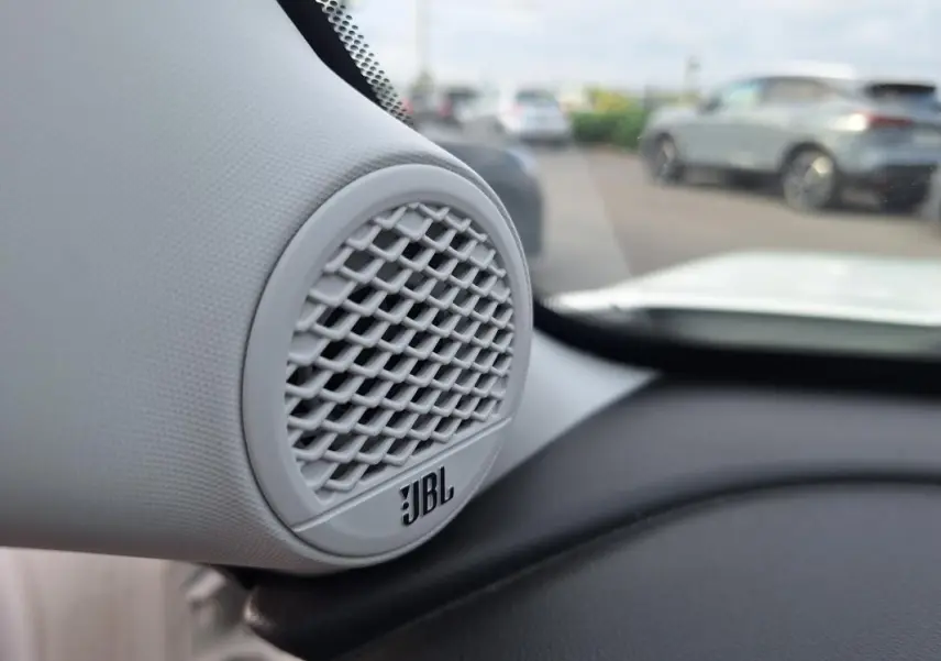 Gros plan sur l'enceinte JBL blanche intégrée au tableau de bord du Jeep Avenger 2025, intérieur clair visible.