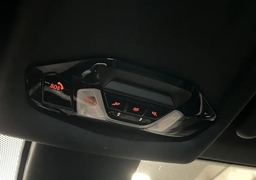 Vue intérieure du plafonnier avec boutons lumineux SOS et commandes d’éclairage dans une BMW Série 1 noire.