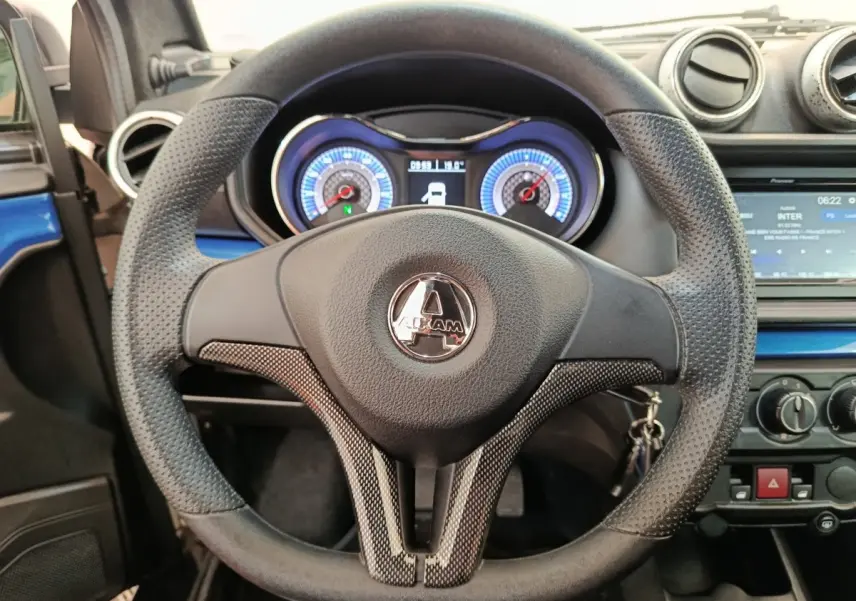 Vue rapprochée du volant noir et du tableau de bord lumineux de l'Aixam Ambition 0.5 City Coupe GTI 2023.