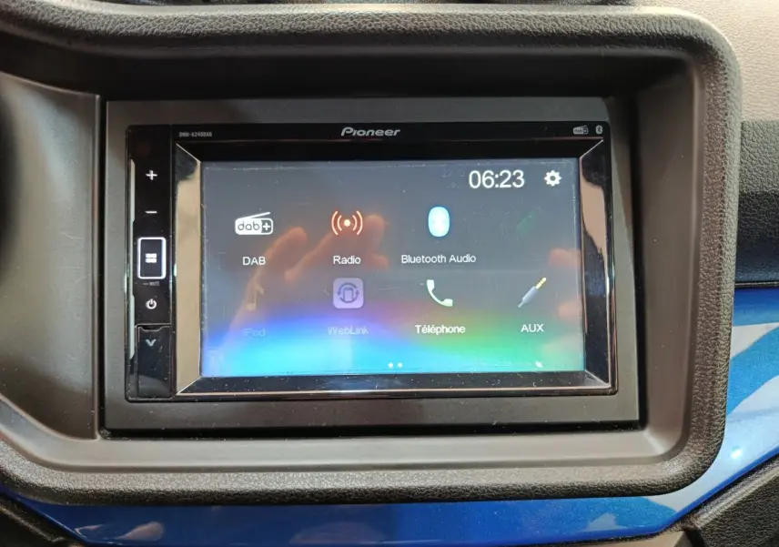 Écran tactile multimédia Pioneer intégré au tableau de bord avec cadre noir et surface bleue en dessous.
