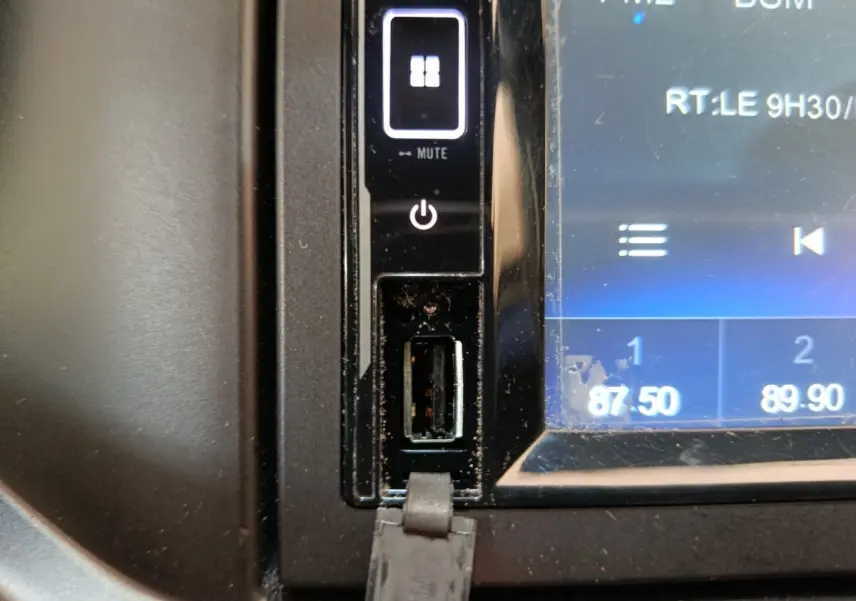 Gros plan sur la prise USB et les commandes tactiles du système multimédia de l'AIXAM Ambition blanc, version 2023.