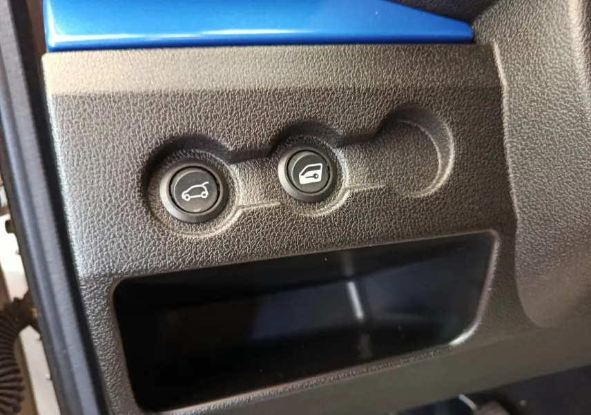 Gros plan sur les boutons d'ouverture du coffre et du capot d'une Aixam Ambition 0.5 City Coupe GTI blanche.