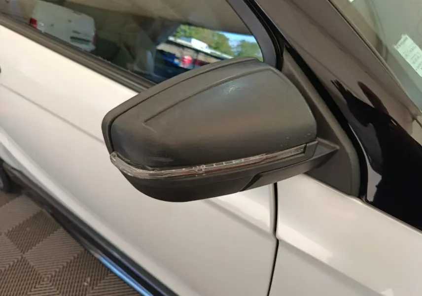 Rétroviseur extérieur côté conducteur noir avec clignotant intégré sur Aixam Ambition blanc, vue rapprochée côté gauche.