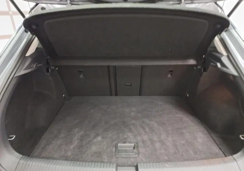 Coffre ouvert du Volkswagen T-Roc 1.5 TSI 150 DSG7 Style 2023, espace de chargement propre et tapis noir.