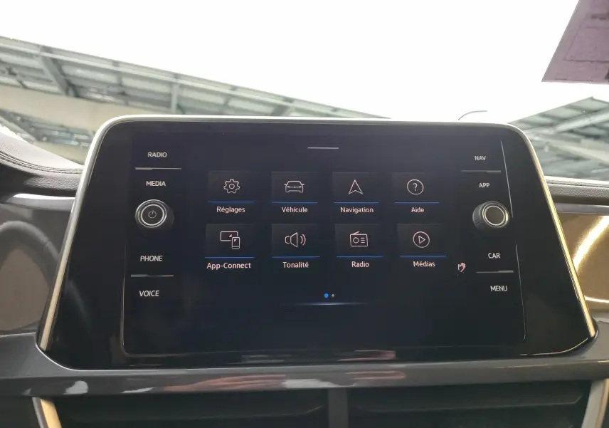 Écran tactile central du Volkswagen T-Roc 2023 affichant le menu principal avec options multimédia et navigation.