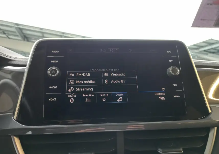 Écran tactile central du Volkswagen T-Roc 2023 affichant les options audio avec interface noire et commandes autour.