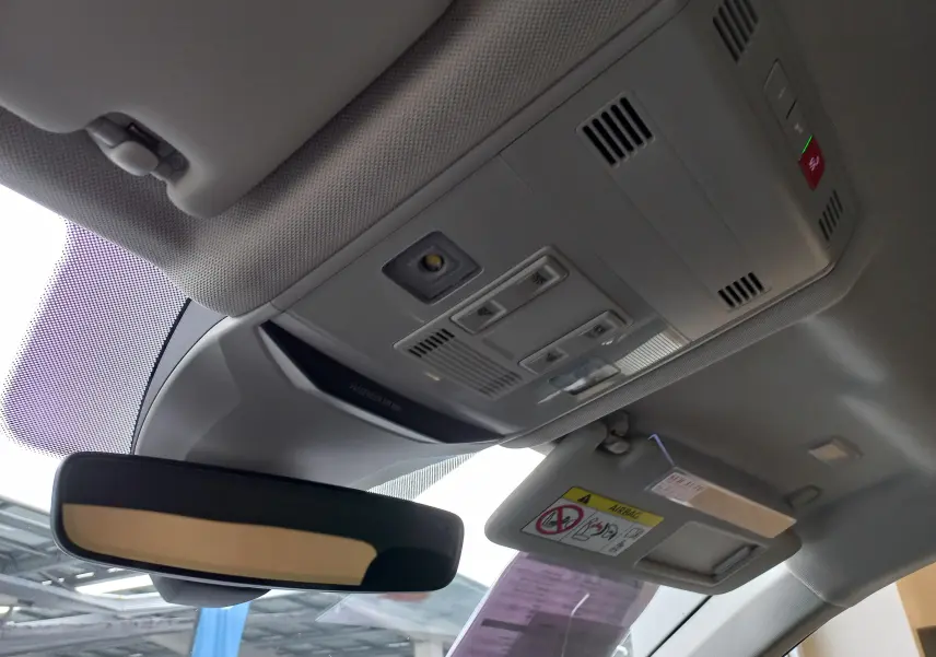 Vue intérieure du plafonnier et du rétroviseur intérieur d'un Volkswagen T-Roc 1.5 TSI gris Pyrite toit noir.