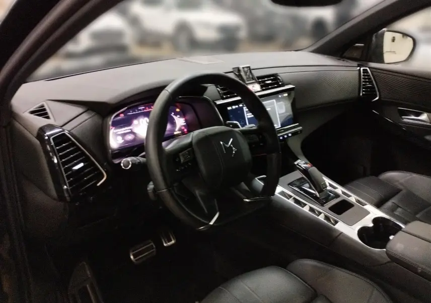 Vue intérieure côté conducteur du DS7 2025 noir Perla, montrant le tableau de bord numérique et la console centrale moderne.