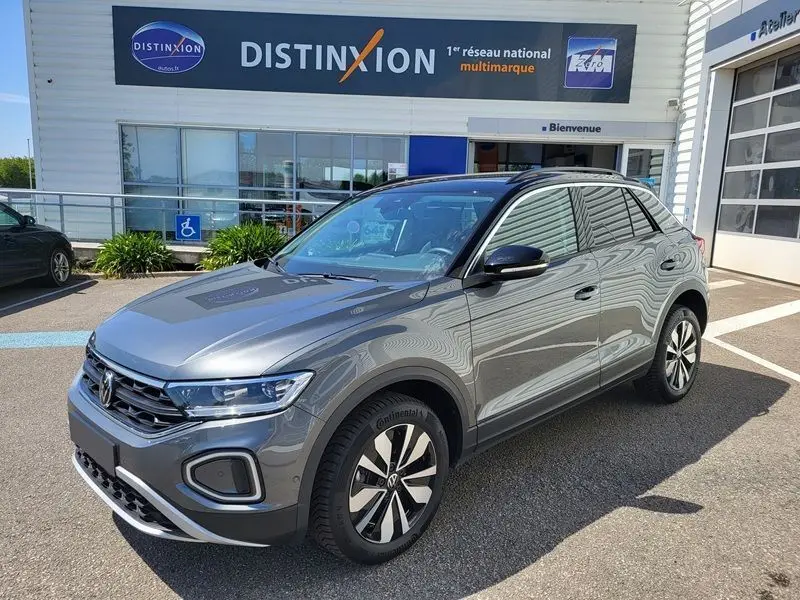 Volkswagen T-Roc gris Indium en 3/4 avant droit, mettant en valeur ses jantes distinctives et son attelage amovible.
