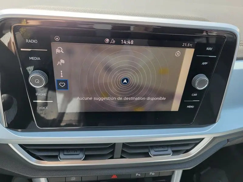 Écran tactile central du Volkswagen T-Roc 2025 affichant le menu de navigation, entouré de commandes multimédia.