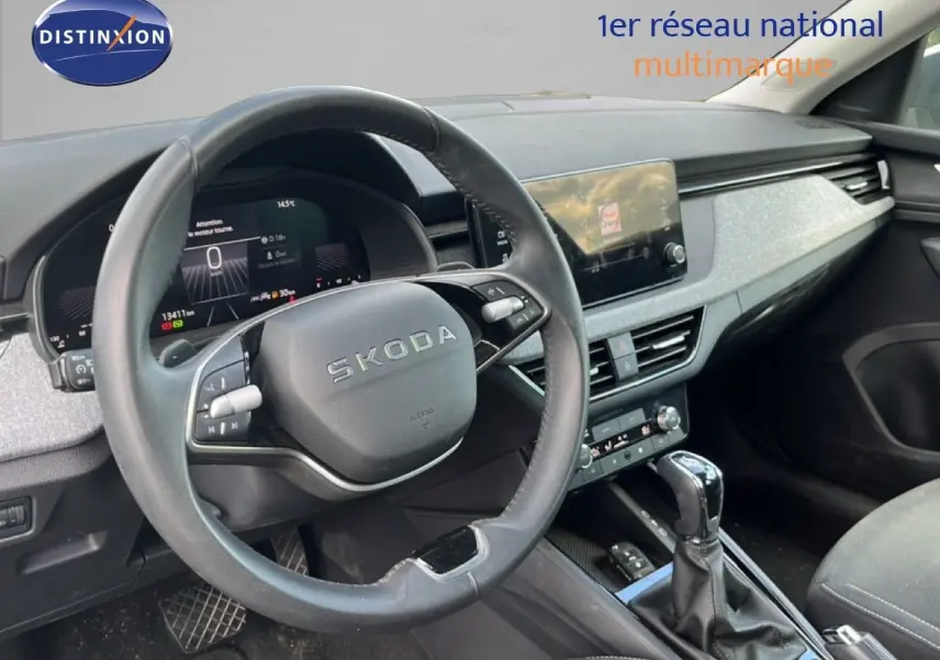 Vue intérieure du poste de conduite de la Skoda Scala gris graphite, avec volant cuir et écran tactile central.