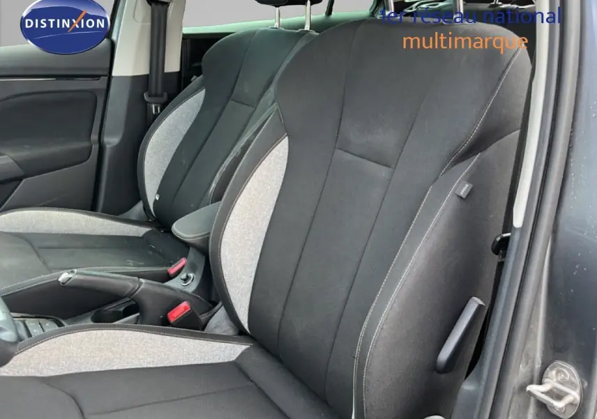 Vue intérieure des sièges avant en tissu gris noir de la Skoda Scala 2025, avec accoudoir central et ceinture visible.