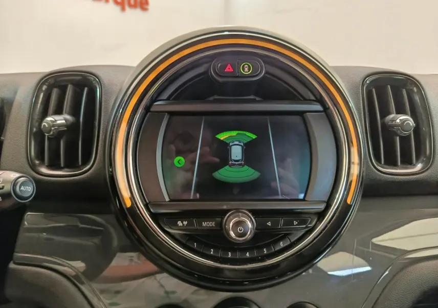 Gros plan sur l’écran central rond du tableau de bord d’une MINI Countryman 2019 noir, affichant l’aide au stationnement.