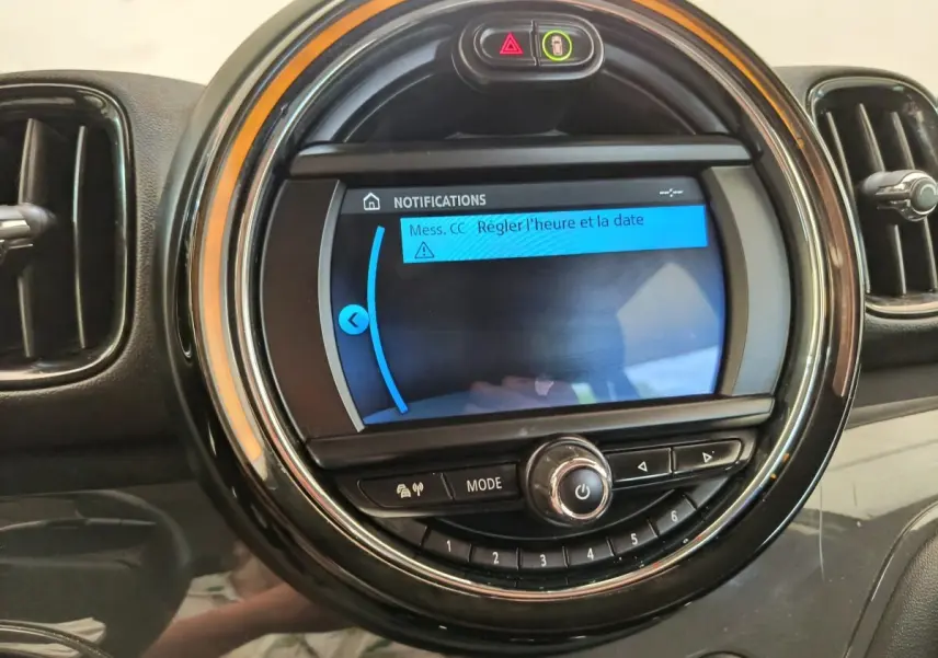 Gros plan sur l'écran central rond du tableau de bord noir du MINI Countryman 2019 avec affichage de notifications.