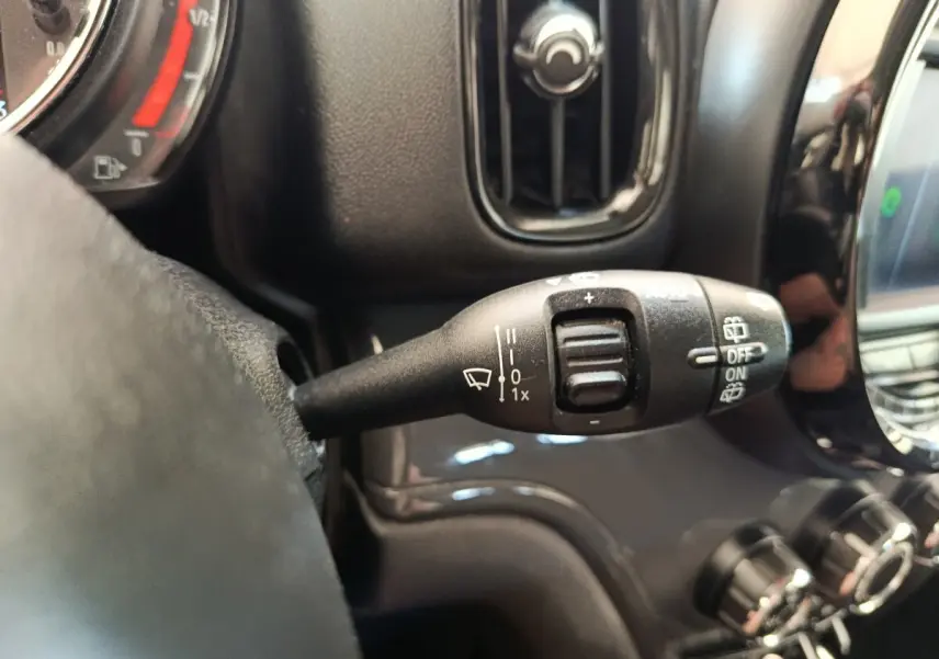 Gros plan sur la commande d'essuie-glace à gauche du volant dans l'habitacle noir d'une MINI Countryman 2019.