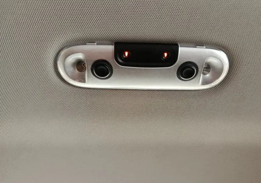 Plafonnier intérieur gris avec deux petites lampes rouges allumées sur une MINI Countryman noire, vue en gros plan.
