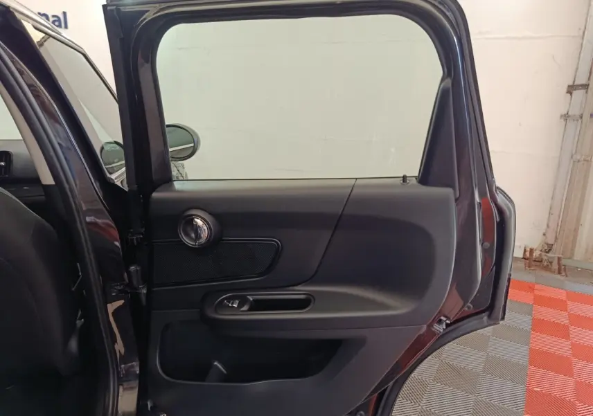 Vue rapprochée de la porte arrière gauche noire ouverte d'une MINI Countryman 2019, intérieur sobre et moderne.