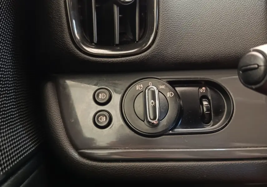 Gros plan sur le panneau de commande des phares et antibrouillards intérieur noir du MINI Countryman 2019.