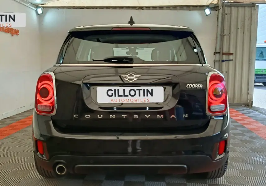 Vue arrière d'une MINI Countryman Cooper noire, avec feux arrière LED et logo distinctif visible.