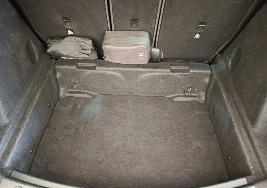Coffre ouvert de MINI Countryman noir 2019, vue plongeante montrant un espace de rangement avec deux sacs noirs.