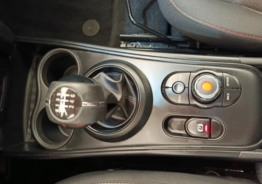 Vue rapprochée de la console centrale noire d’une MINI Countryman 2019 avec levier de vitesse manuel et commandes multimédia.