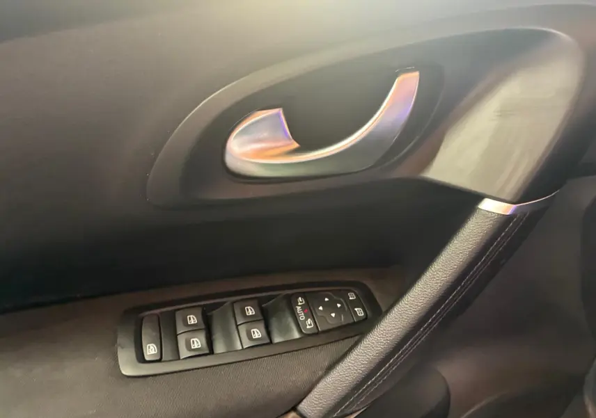 Poignée de porte intérieure côté gauche avec commandes des vitres sur Renault Kadjar gris, finition tissu noir.