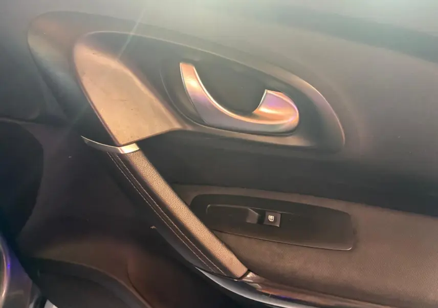 Poignée de porte intérieure côté gauche du Renault Kadjar 2019, finition tissu noir avec bouton de verrouillage.