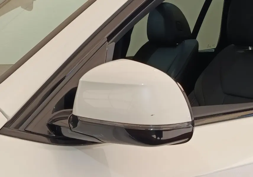 Gros plan sur le rétroviseur droit blanc du BMW X3 xDrive30e 2023 avec intérieur noir visible en arrière-plan.