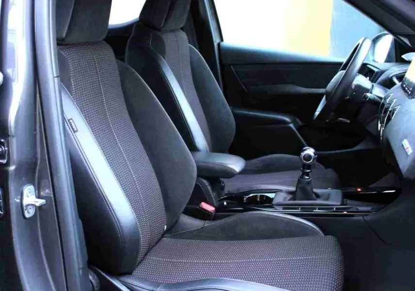 Vue intérieure côté conducteur du DS3 Crossback gris platinium, montrant les sièges en tissu et cuir noir avec levier de vitesse manuel.