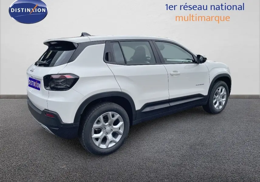 Jeep Avenger blanc neige vu de 3/4 arrière côté gauche, avec jantes argentées et feux arrière fumés.