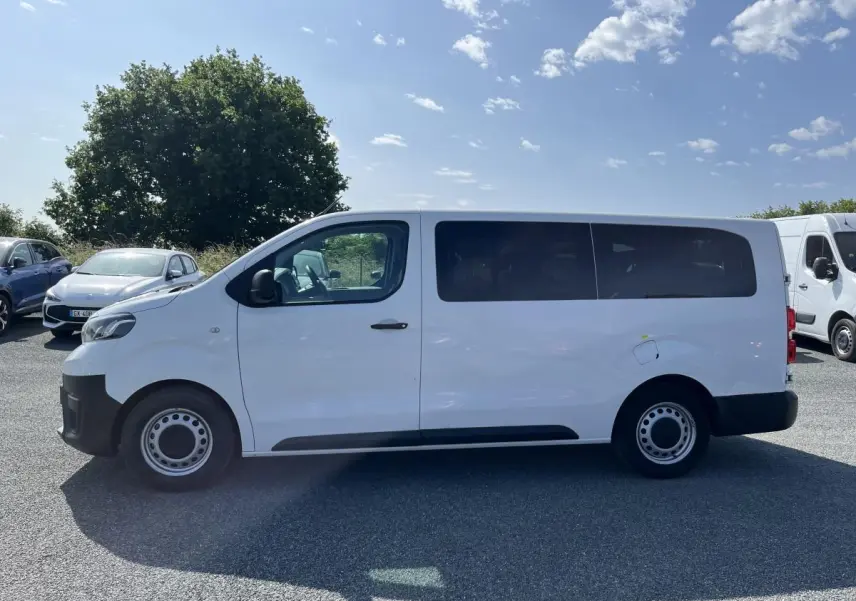 Profil côté gauche d'un Toyota Proace Fourgon blanc 2021 avec portes vitrées et jantes acier 16 pouces.
