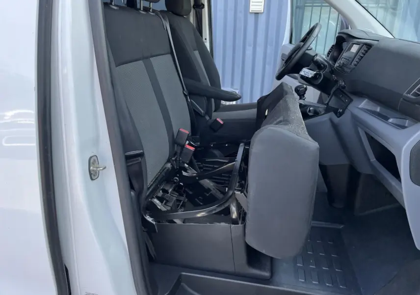 Vue intérieure côté gauche du Toyota Proace Fourgon blanc 2021, siège passager avant relevé montrant la structure métallique.