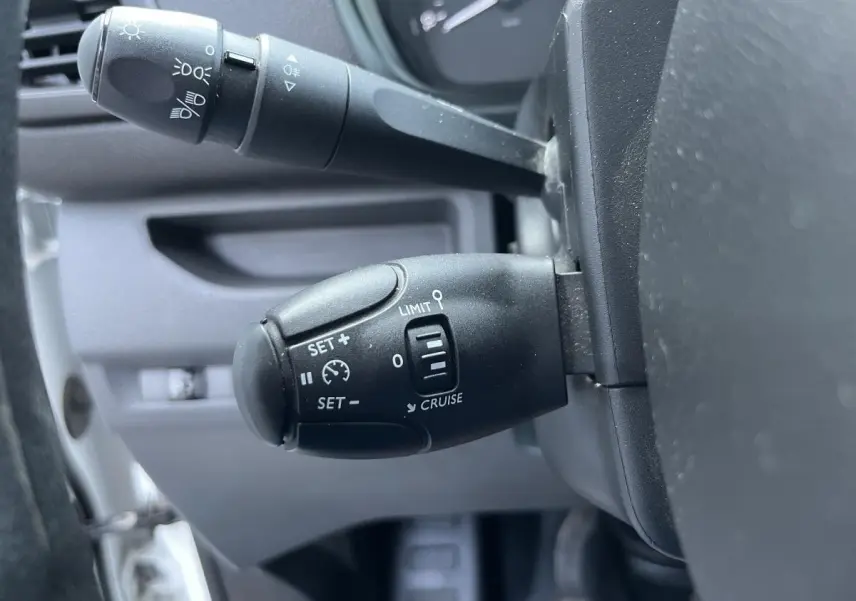 Gros plan sur la commande de régulateur de vitesse du Toyota Proace Fourgon 2021, intérieur gris.