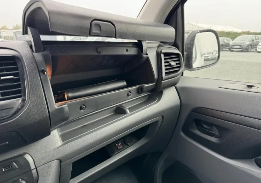 Intérieur côté passager du Toyota Proace Fourgon blanc 2021, avec boîte à gants ouverte et tableau de bord gris.