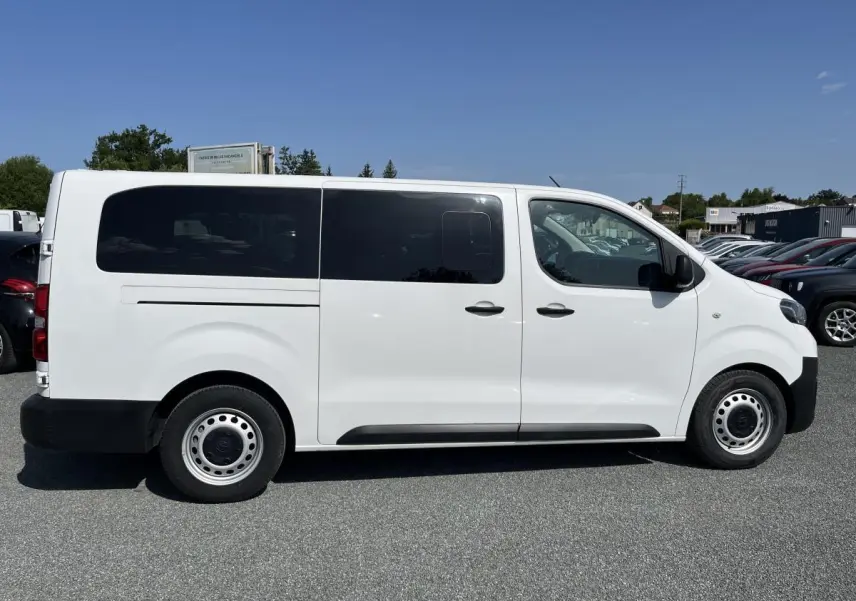 Profil côté gauche du Toyota Proace Fourgon blanc 2021 avec portes latérales coulissantes vitrées et jantes acier 16 pouces.